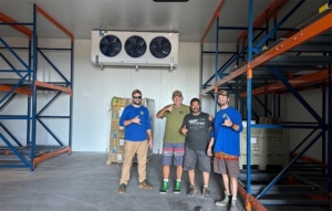 Co-op Members standing in a large freezer room in Honalo