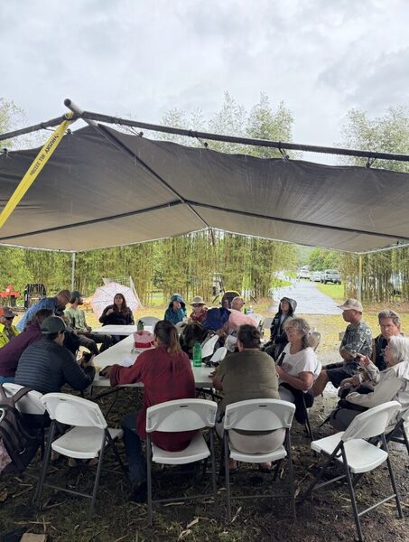 East Hawaiʻi farmer-members seated under a canopy at a regional member meeting